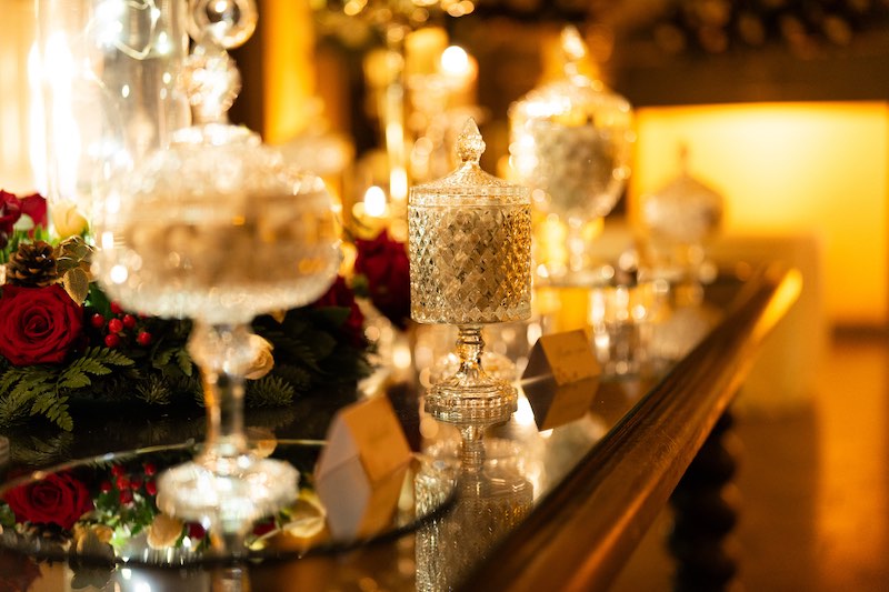 In questa foto un dettaglio della Sweet Table di un matrimonio a tema Natale decorato dal Wedding Planner Stefano Miranda con vasi di vetro e fiori di colore rosso 