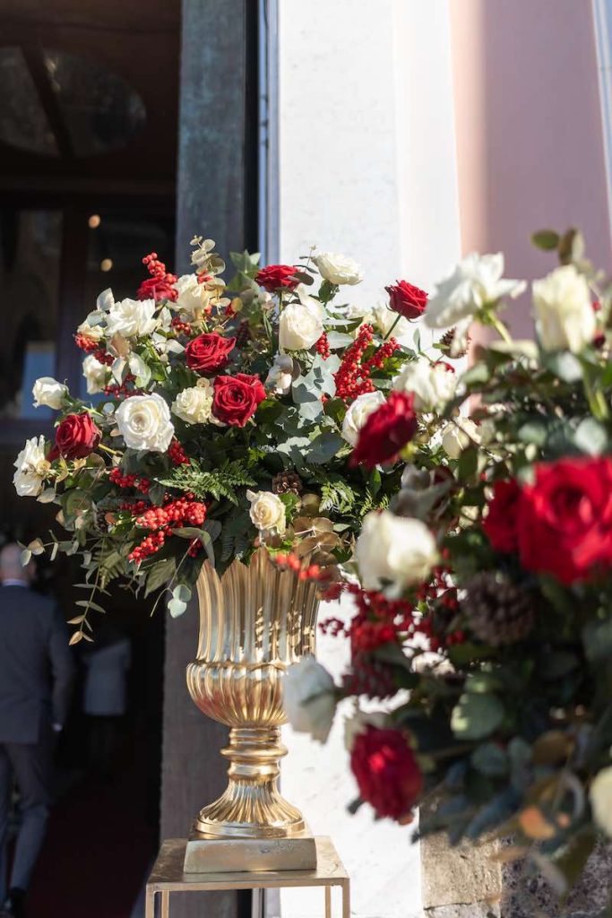 In questa foto una composizione di rose di colore bianco e rosso, bacche,  eucalipto e pungitopo posto davanti alla chiesa del matrimonio di Matteo e Pina allestito dal Wedding Planner Stefano Miranda