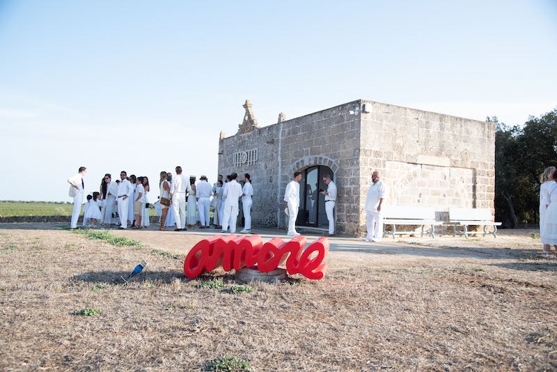 In questa foto alcuni invitati a un Wine Wedding a Masseria Cuturi dove compare la scritta "Amore"