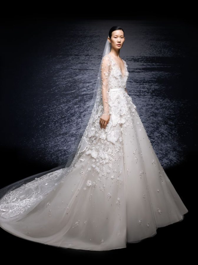 In questa foto la modella indossa un abito da sposa Elie Saab 2024 Spring Summer con fiori tridimensionali