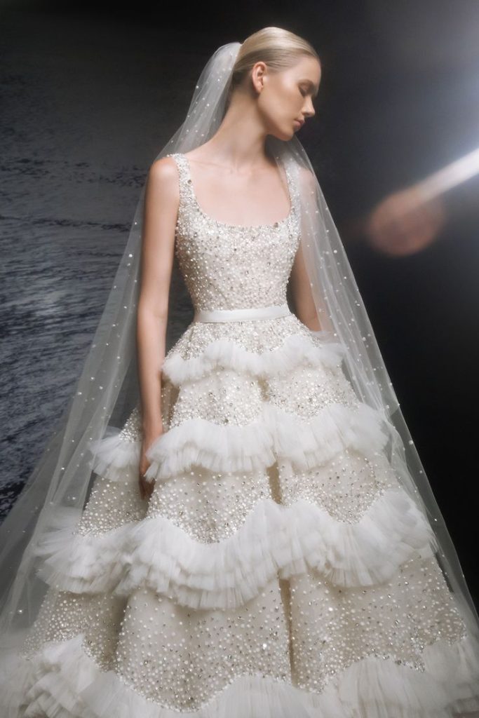 In questa foto la modella indossa un abito da sposa Elie Saab 2024 Spring Summer con micro balze di tulle.