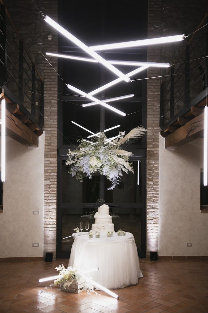 In questa foto il tavolo della torta con un particolare allestimento aereo di neon, realizzato dalla Wedding Planner Elisa Azzolini