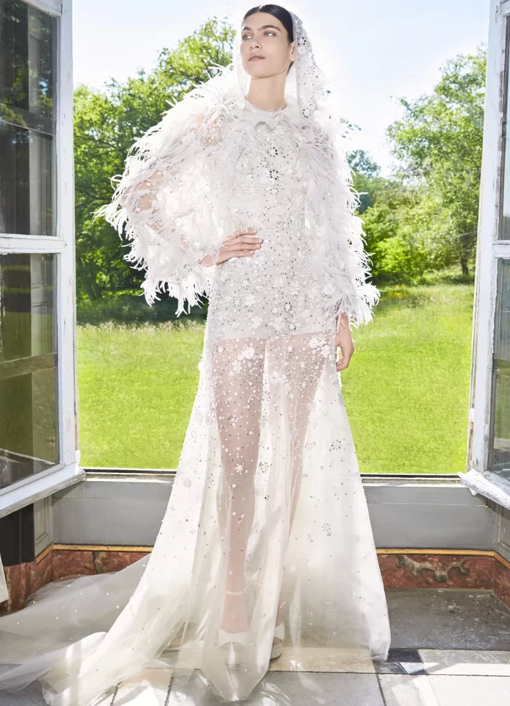 In questa foto la modella indossa un abito da sposa Elie Saab 2024  corto con piume.