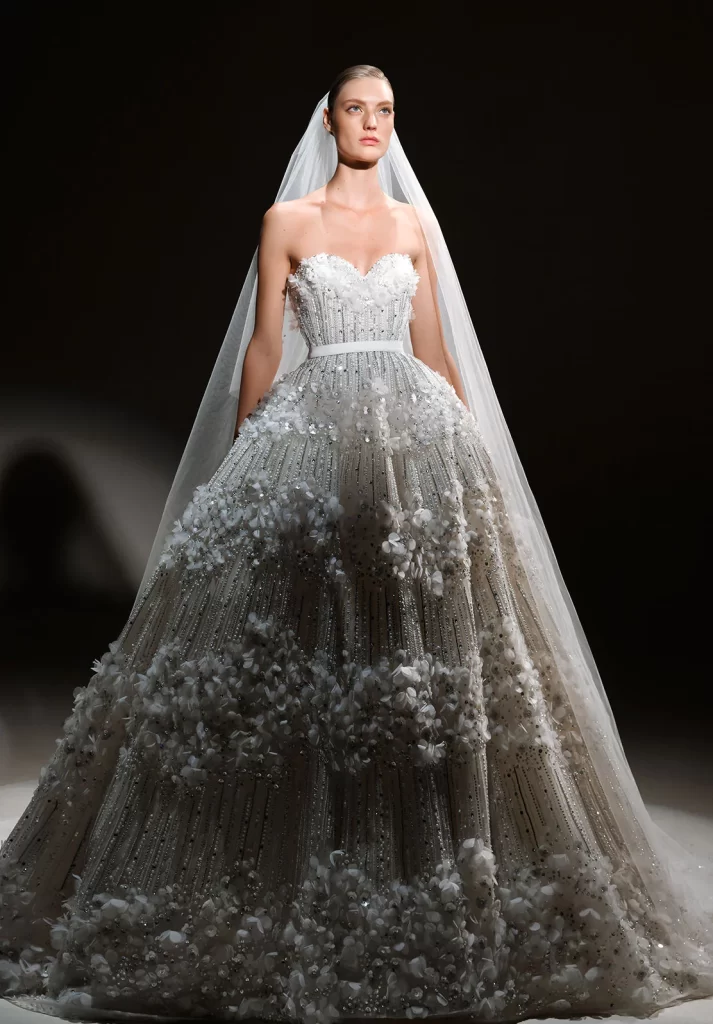 In questa foto la modella indossa un abito da sposa Elie Saab 2024 con fiori tridimensionali 