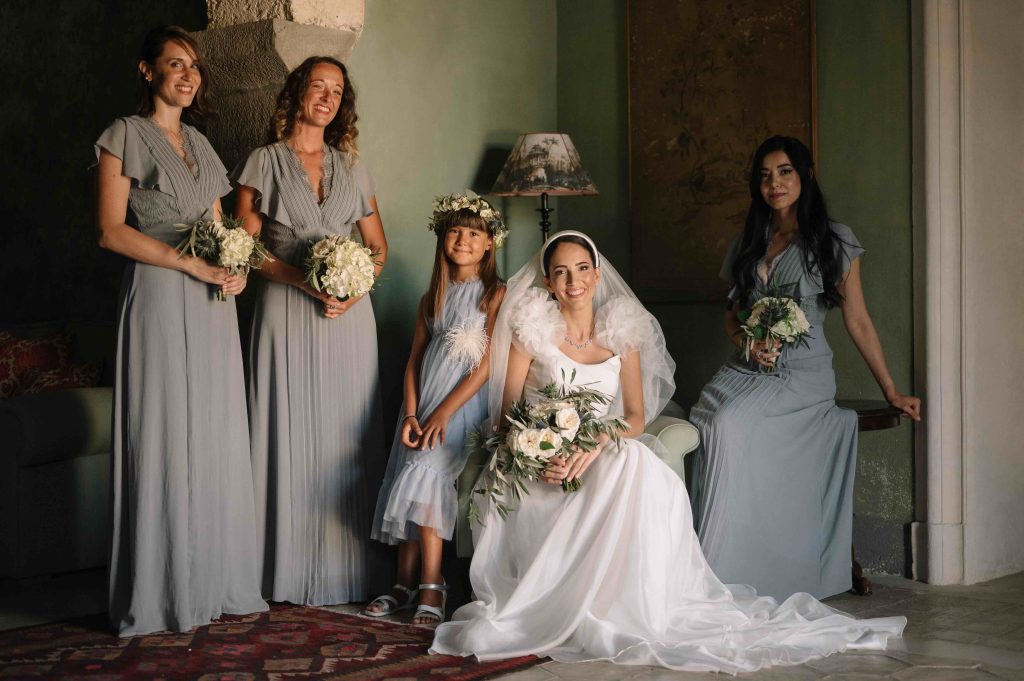 In questa immagine la sposa insieme alle damigelle vestite d'azzurro polvere.