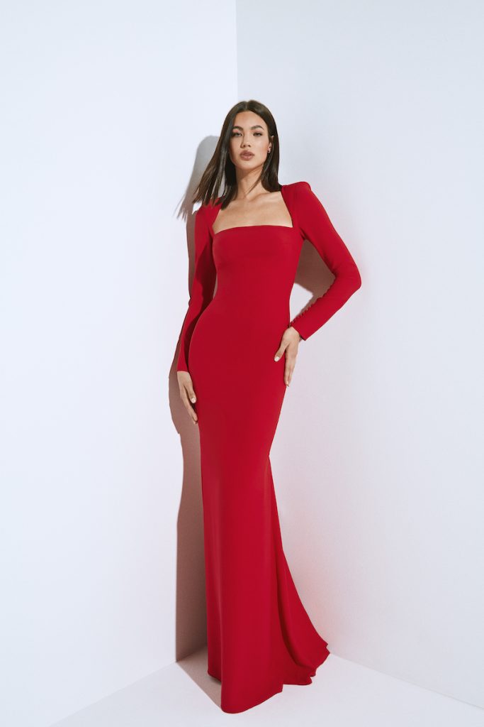 In questa foto una modella indossa un abito da sera a sirena, in rosso audace e sensuale, della collezione cerimonia 2024 di Pronovias