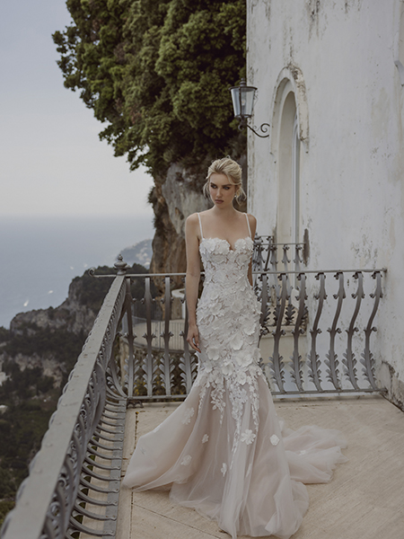 In questa foto la modella indossa un abito Ricca sposa a sirena con fiori.