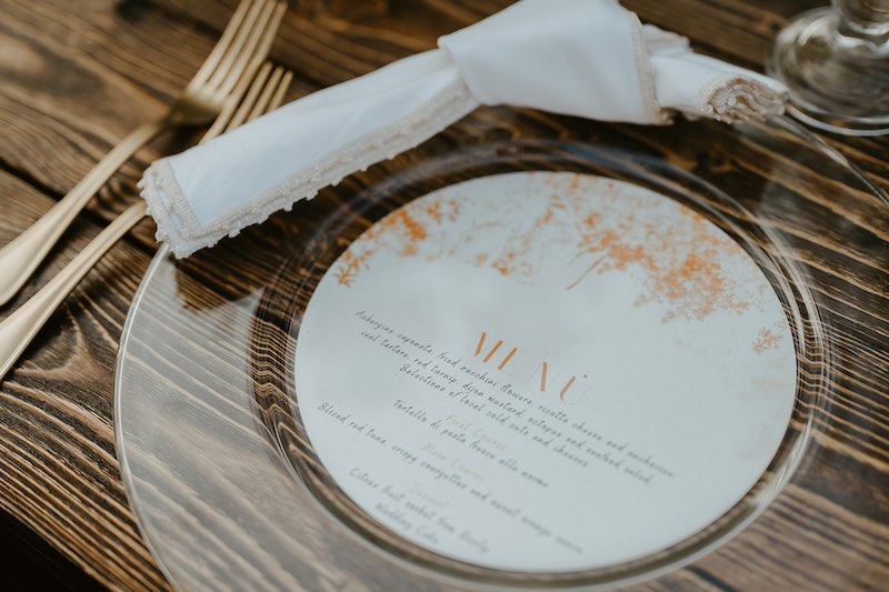 In questa foto il dettaglio della mise en place di un Elopement Wedding in Sicilia progettato da Tania Costantino con menu personalizzato e tovagliolo ricamato