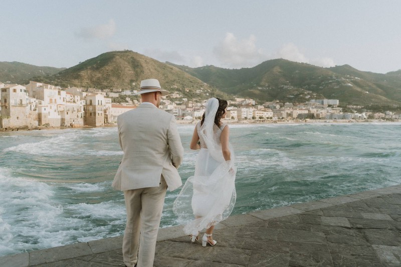 In questa foto due sposi in riva al mare di Cefalù