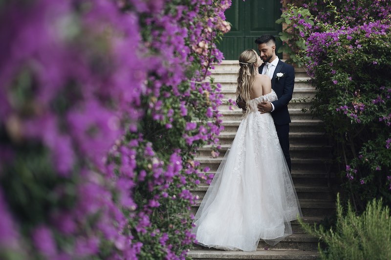 In questa foto di Serena Libutti due sposi circondati da bouganville si abbracciano e si guardano innamorati