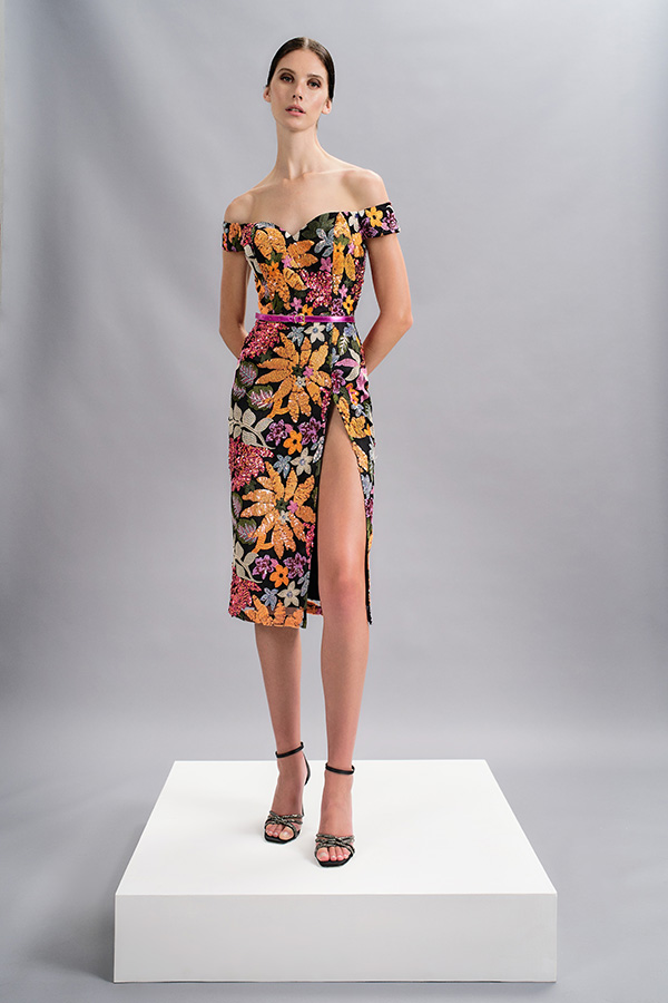 In questa foto la modella indossa un abito a tubino con fiori MIschalis