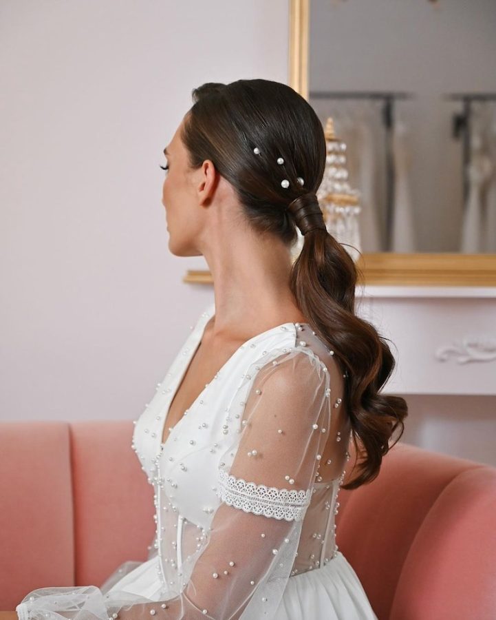 in questa foto una ponytail da sposa decorata con piccole perle