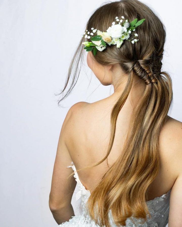 In questa foto una ponytail con trecce e fiori freschi