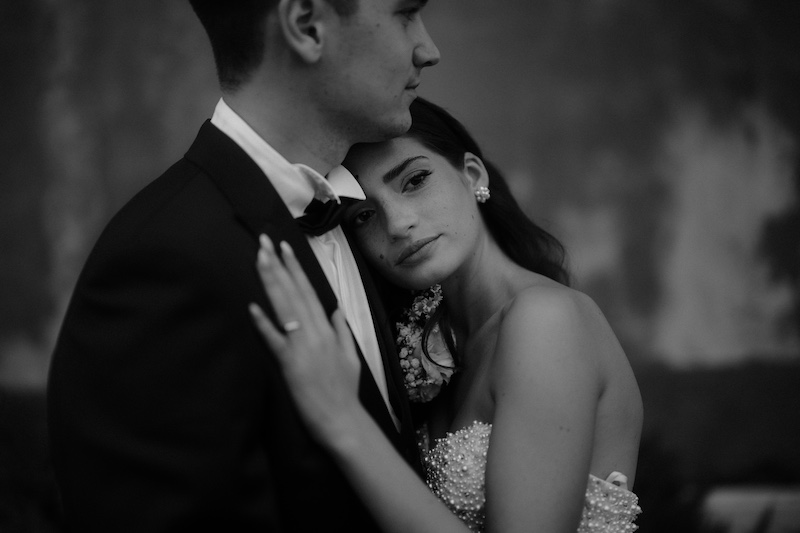 In questa foto in bianco e nero di Alessio Bazzichi il dettaglio di un abbraccio tra due sposi: la sposa tiene la testa sulla spalla sinistra del suo sposo