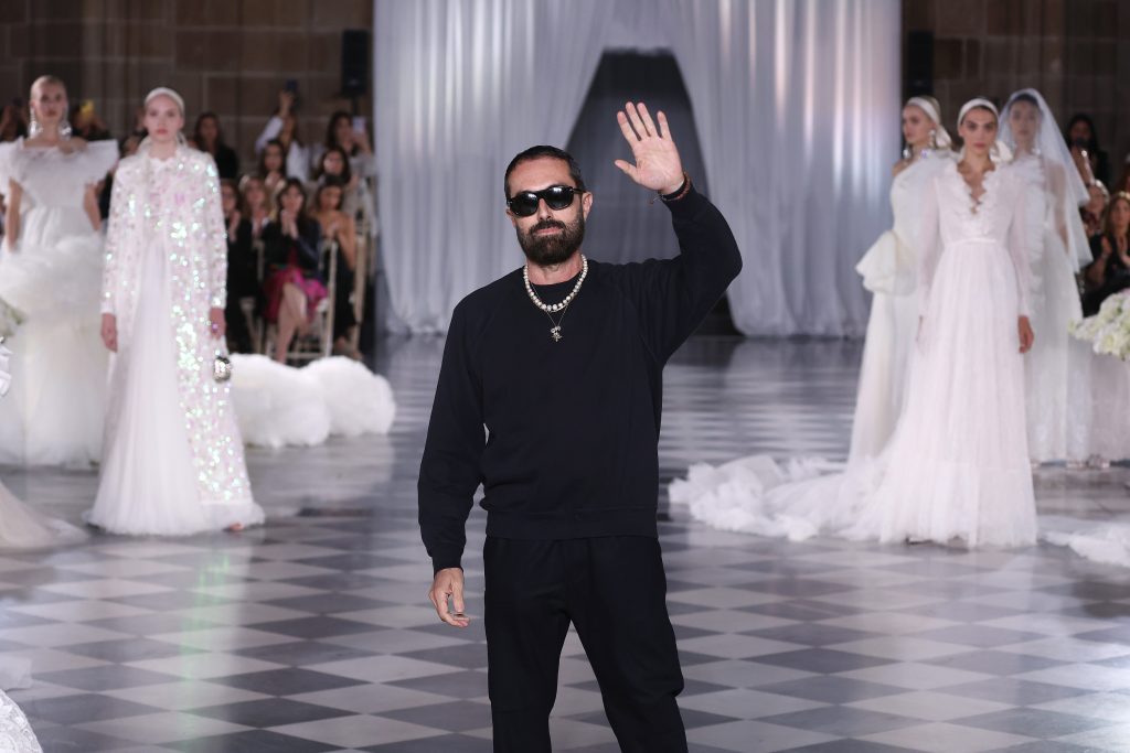 In questa immagine Giambattista Valli ringrazia il pubblico a fine sfilata. 