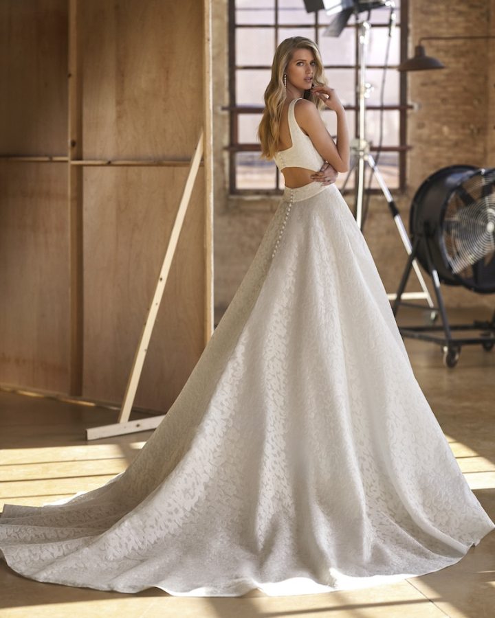 In questa foto una modella posa di spalle indossando un abito da sposa Aire Atelier 2025 ad A