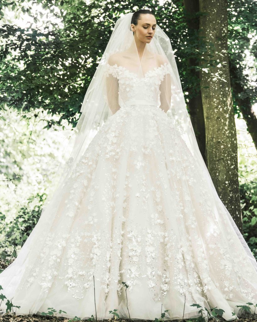 In questa immagine un abito da sposa romantico 2025 di Elie Saab con fiori tridimensionali.