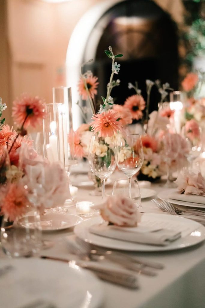 In questa foto il dettaglio di uno dei tavoli imperiali del matrimonio di Carrie e Adam decorato da Imène Hanafi con fiori nelle grandazioni del rosa, porcellane, candele e candelabri di vetro