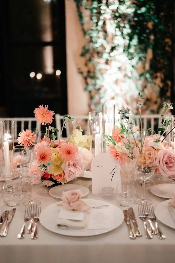 In questa foto il dettaglio di uno dei tavoli imperiali del matrimonio di Carrie e Adam decorato da Imène Hanafi con fiori nelle grandazioni del rosa, porcellane, candele e candelabri di vetro