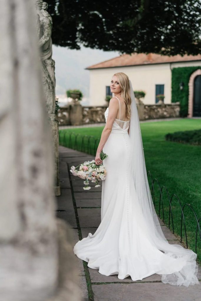 In questa foto la sposa Carrie mentre posa per i viali di Villa del Balbianello mostrando il suo bouquet