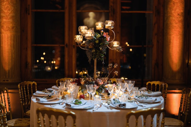 In questa foto il dettaglio di un tavolo matrimonio allestito a Villa Corsini per un matrimonio invernale con candele e rami di pino