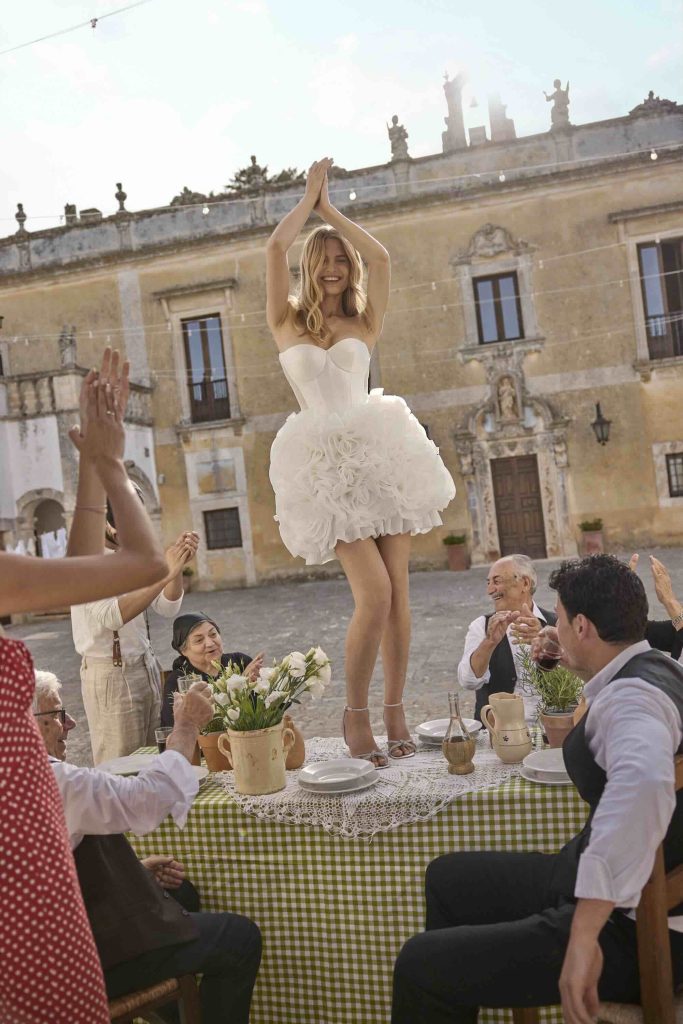 In questa immagine un abito da sposa corto, con gonna floreale in 3D, di Ricca Sposa. 