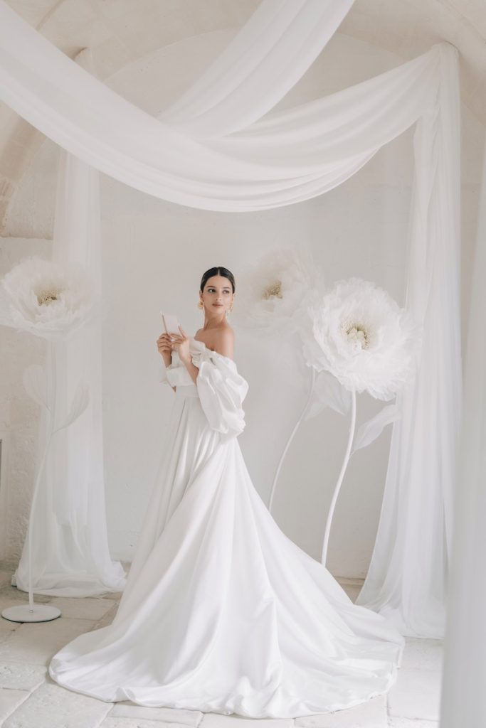 In questa foto una sposa tra due fiori giganti di colore bianco per un matrimonio invernale firmato da Carlotta Cioffi