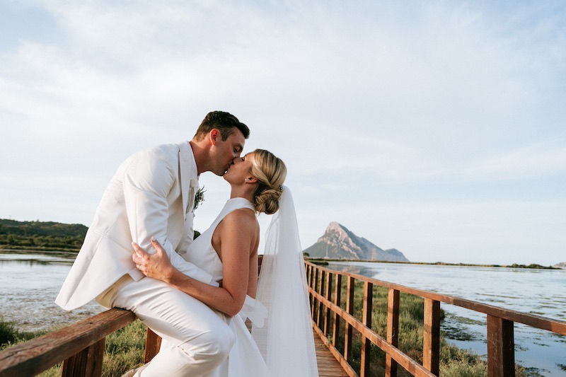 In questa foto due sposi che si baciano durante un Holiday Wedding in Sardegna di Francesca Pittau