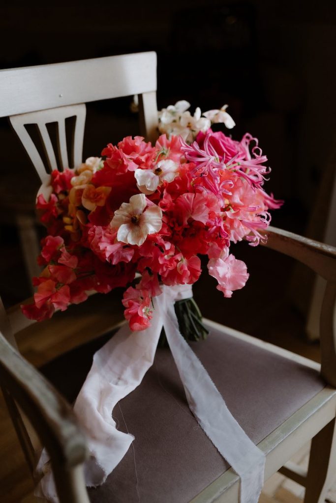 In questa foto, un bouquet da sposa nei toni del fuscia e del rosa