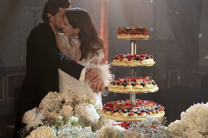 In questa foto, due sposi durante il taglio di una millefoglie a piani con crema e decorata con frutti di bosco