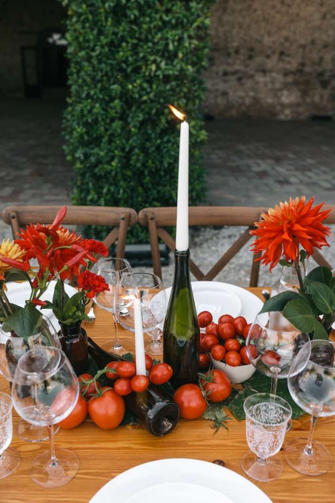 In questa foto, una mise en place per matrimonio nei toni del rosso con pomodori