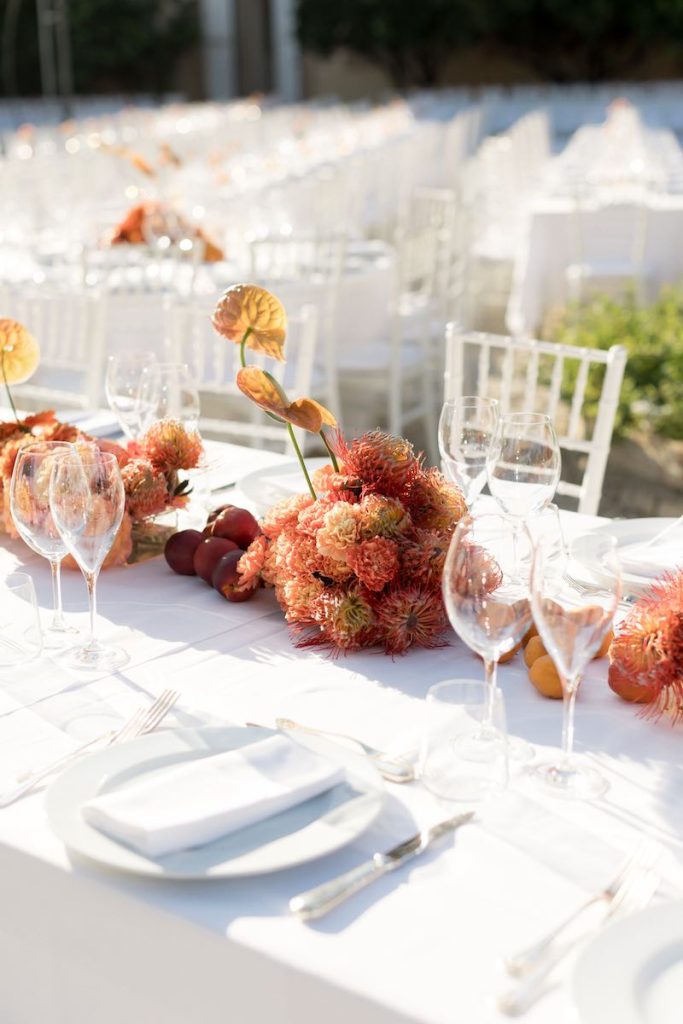 In questa foto, una mise en place per matrimonio color bianco e arancione