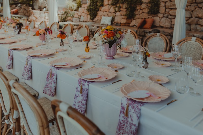 In questa foto, una mise en place per matrimonio color bianco, arancione e bordeaux