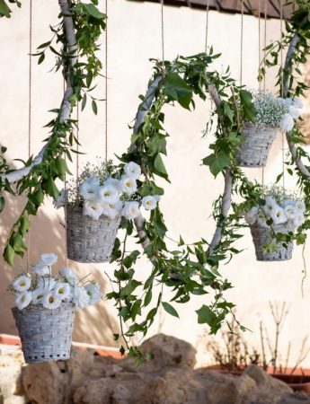 In questa foto un tableau de mariage con vasi appesi e fiori bianchi