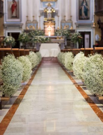 In questa foto una chiesa decorata per un matrimonio con fiori velo da sposa