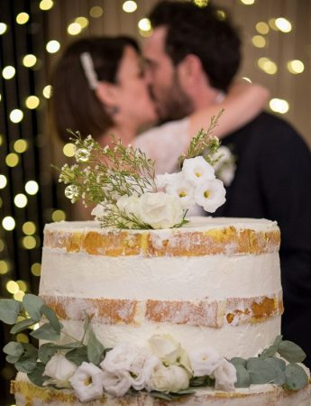 In questa foto due sposi al taglio della loro naked cake