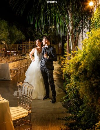 In questa foto due sposi posano durante il loro shooting fotografico serale in un giardino